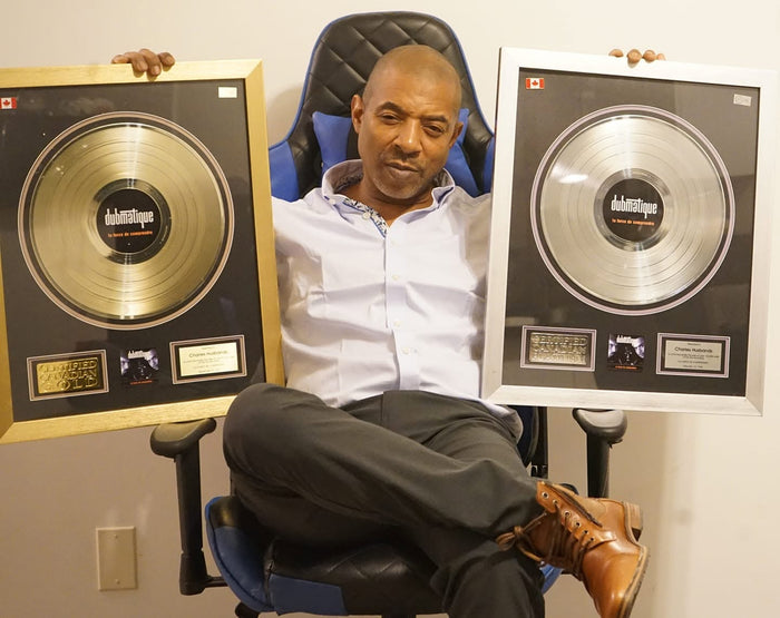 Chuck Ice seated with Canadian gold and platinum music recognition plaques