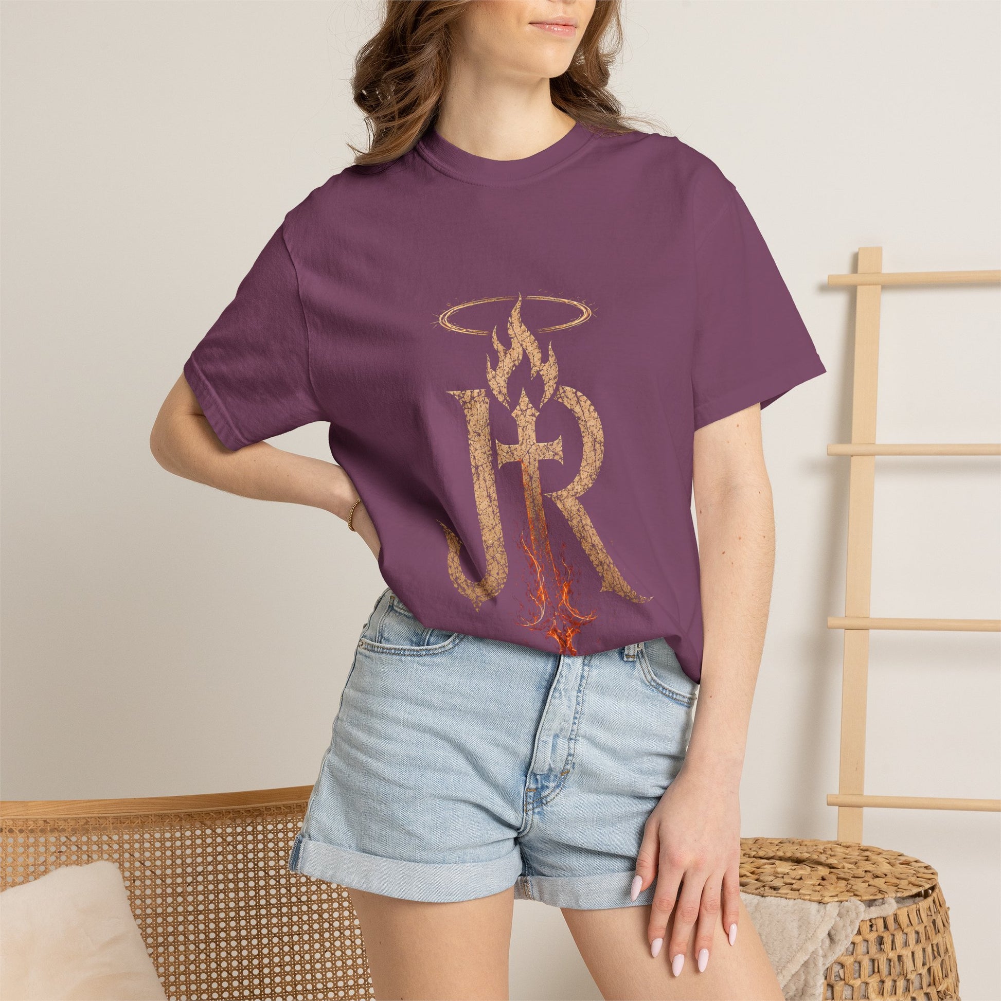 Person wearing a purple t-shirt with a logo and text, standing against a neutral background.