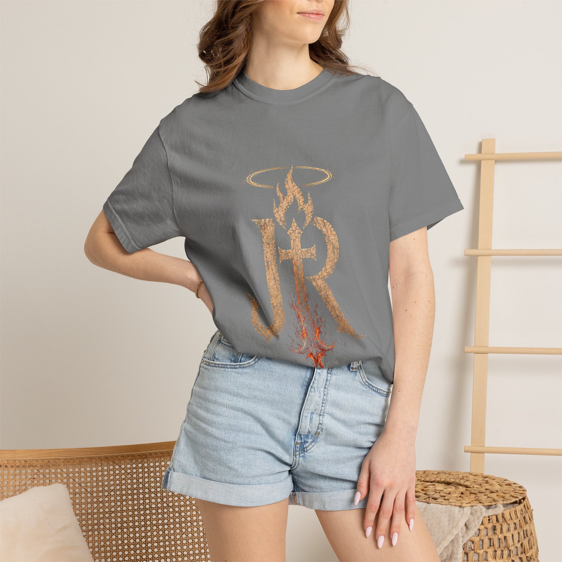 Person wearing a gray t-shirt with a logo and denim shorts in a casual setting