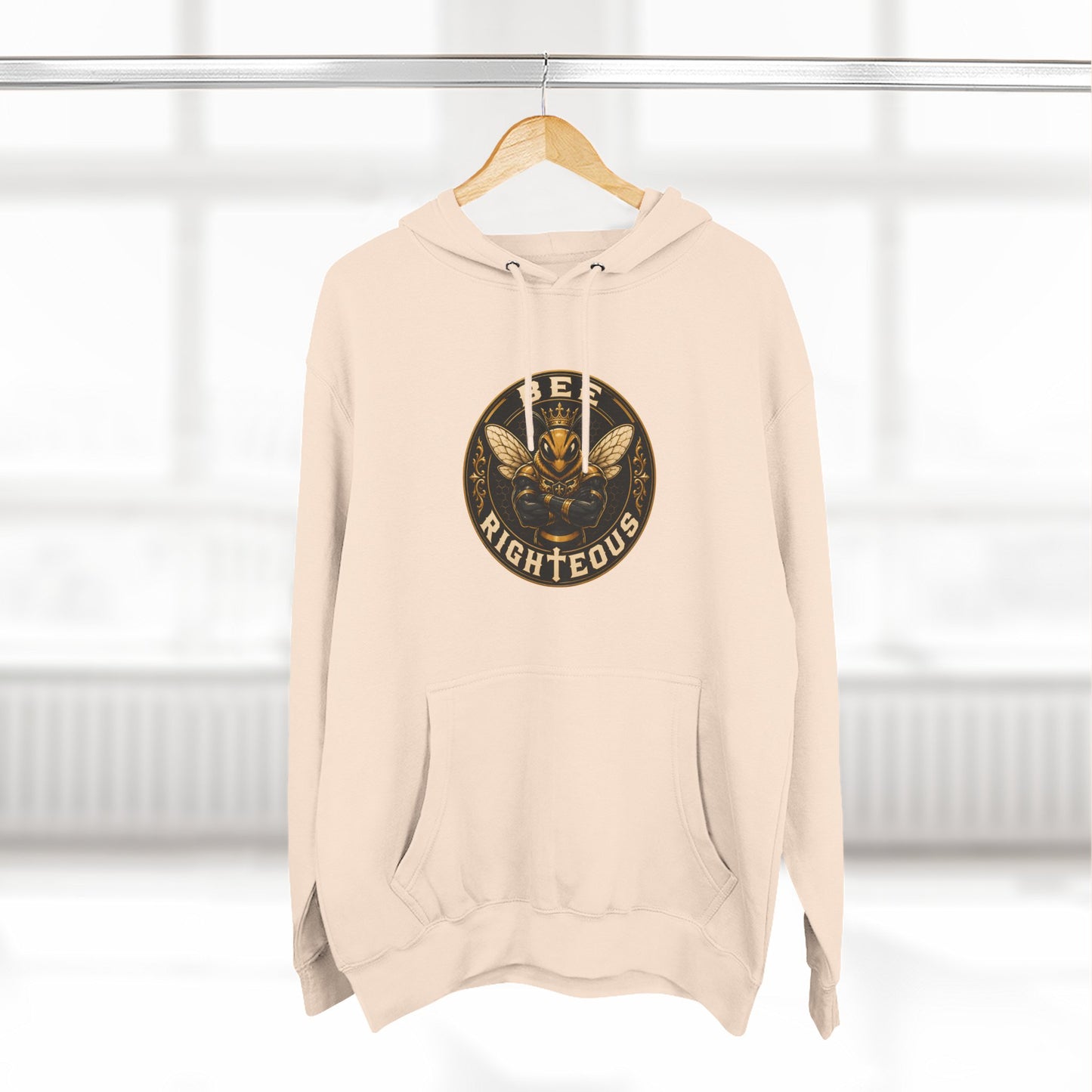 Beige hoodie with a graphic design on a hanger against a white background