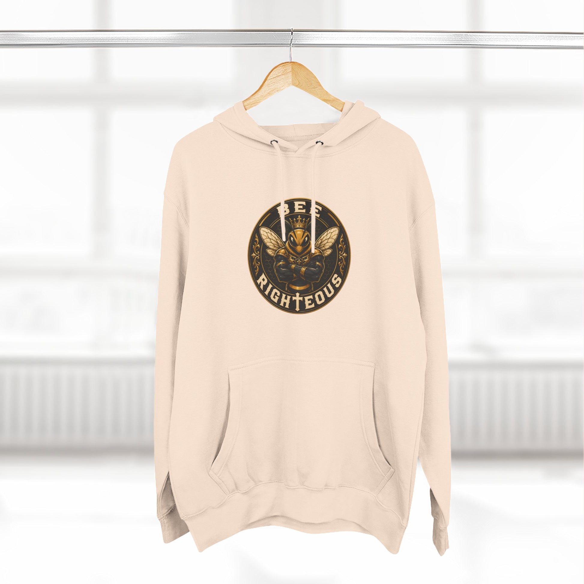 Beige hoodie with a graphic design on a hanger against a white background