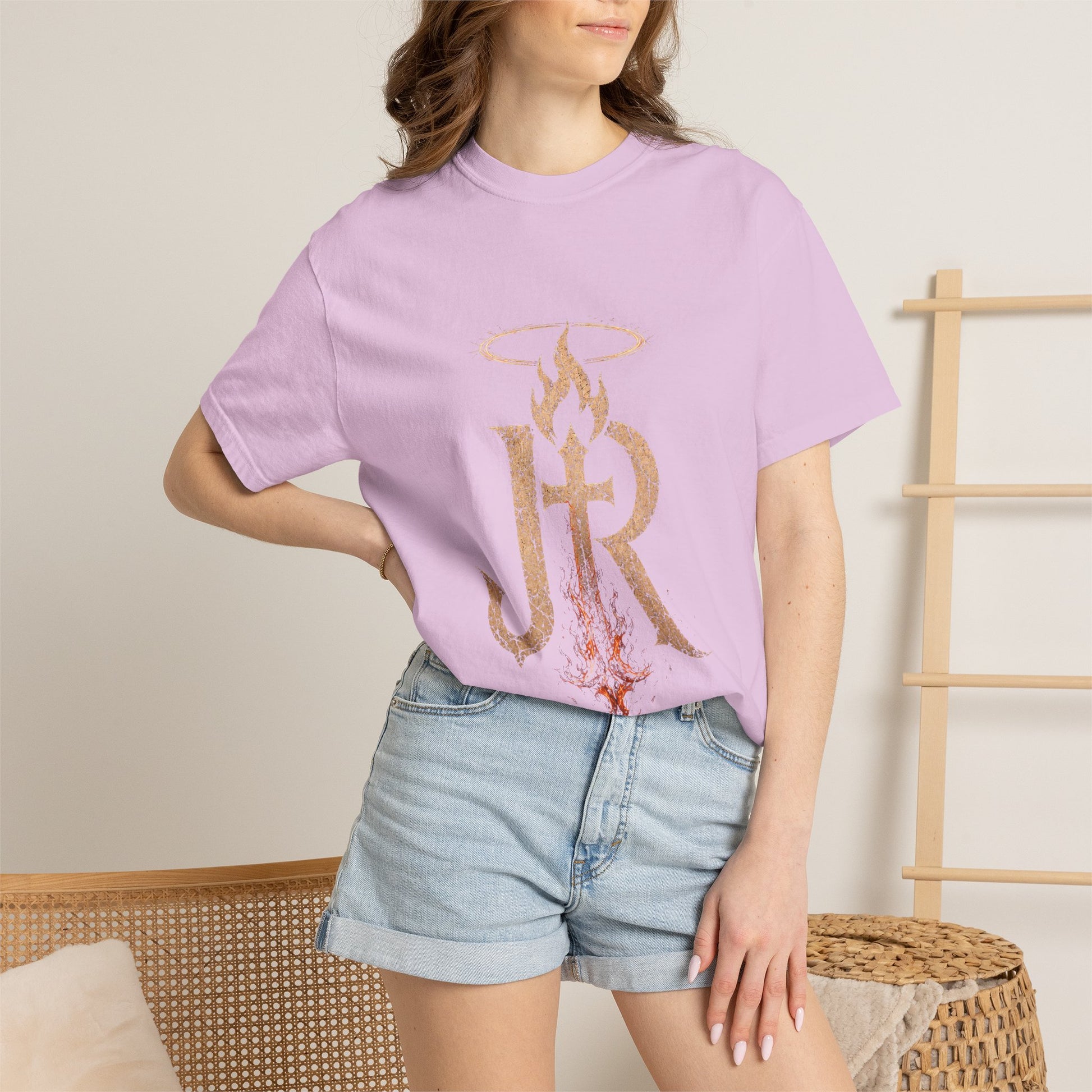 Person wearing a light purple t-shirt with a graphic design and denim shorts against a neutral background