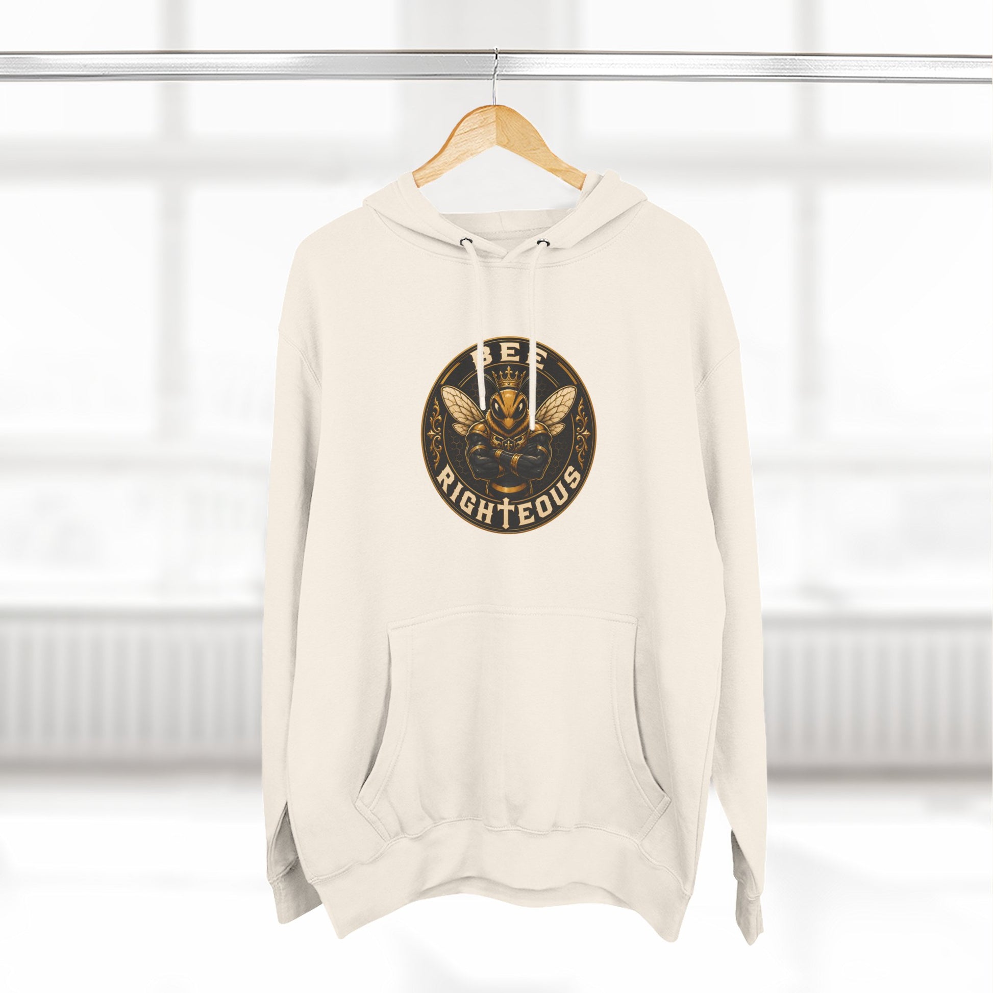 Beige hoodie with a logo on a hanger against a white background