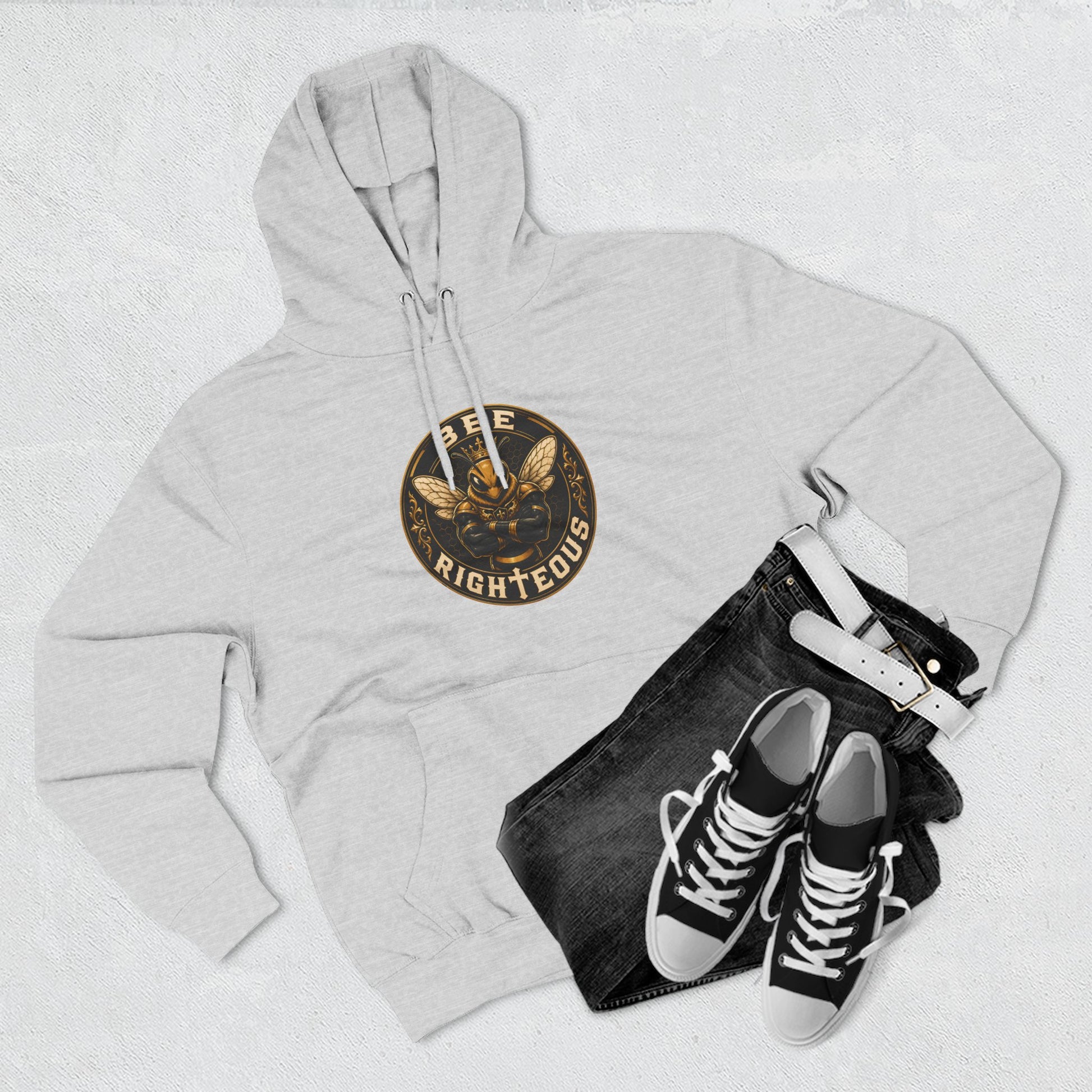 Gray hoodie with a logo, black jeans, and black sneakers on a light gray background