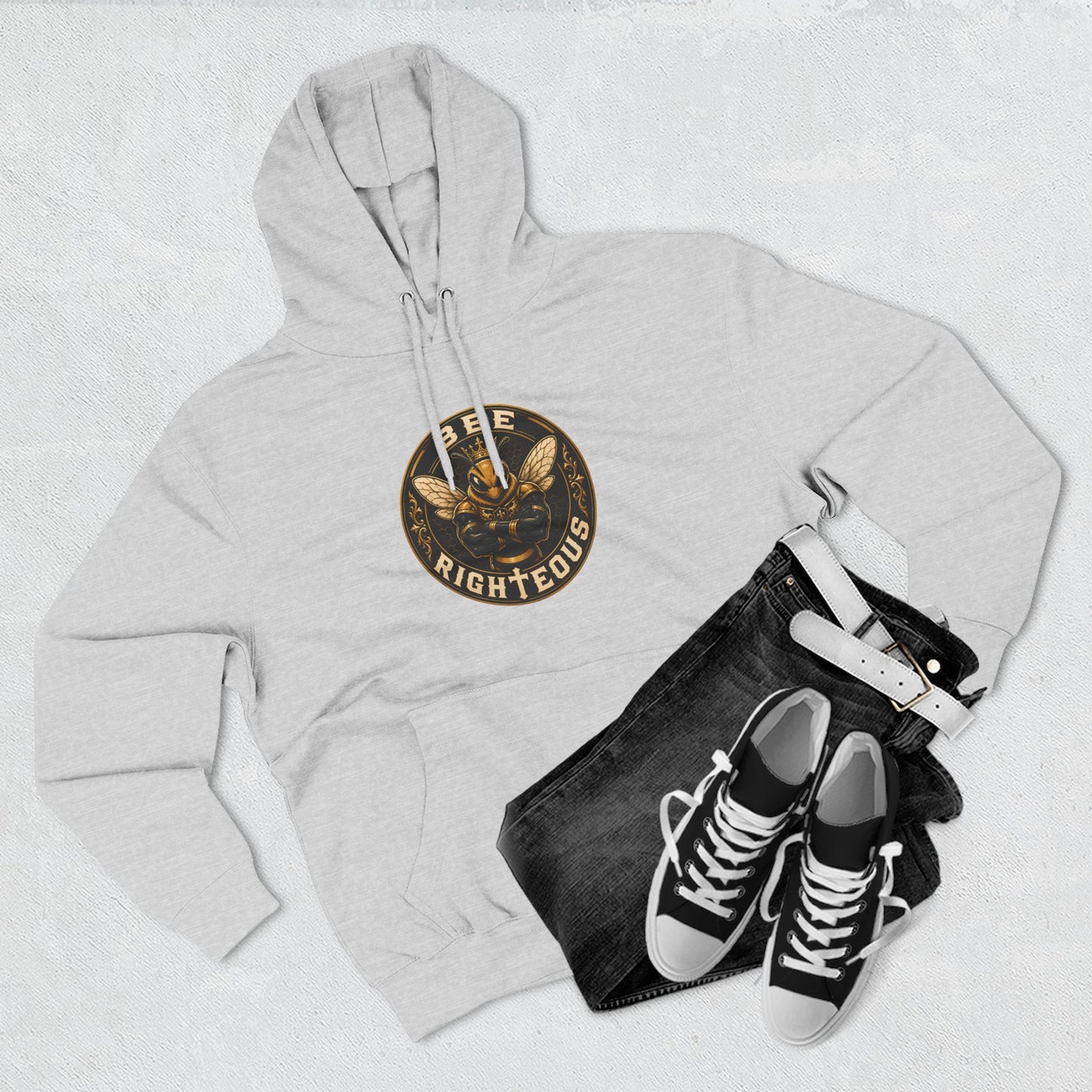 Gray hoodie with a logo, black jeans, and black sneakers on a light gray background