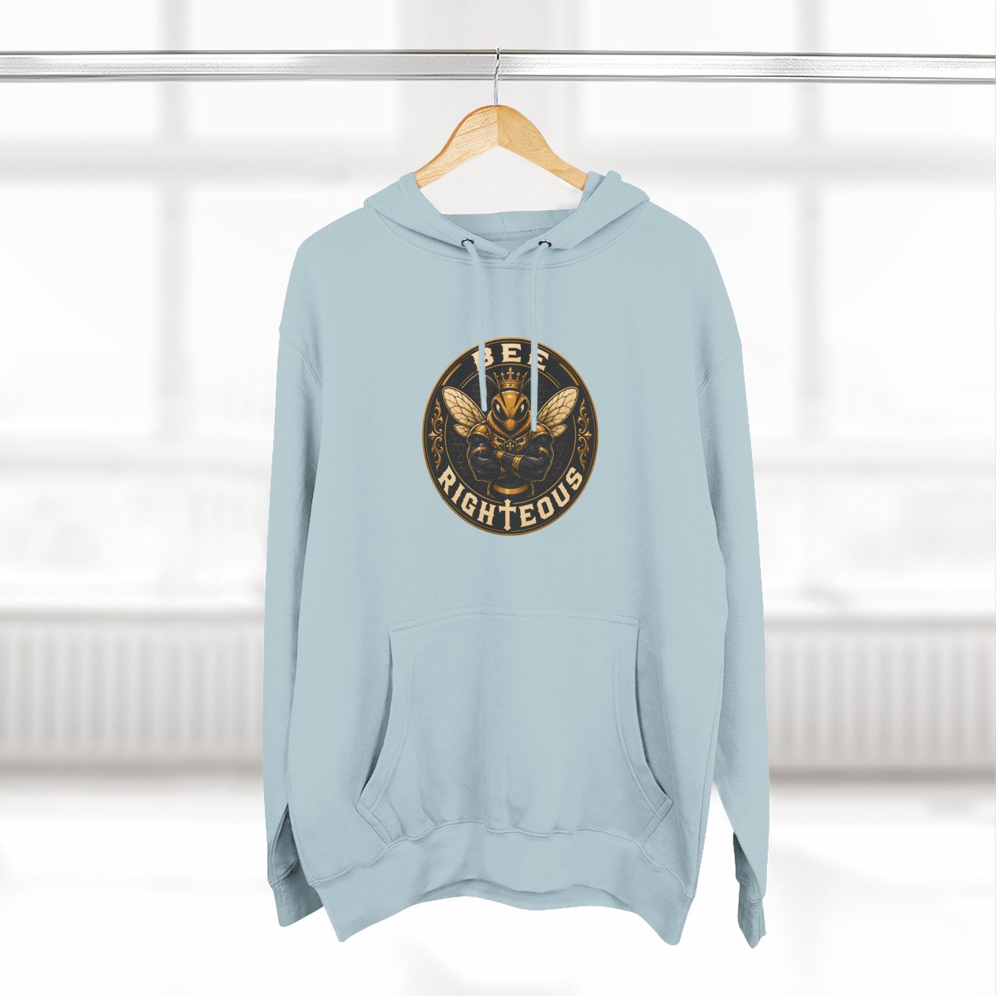 Light blue hoodie with a logo on a wooden hanger against a white background