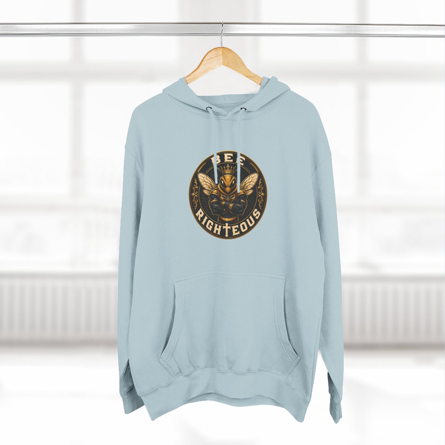 Light blue hoodie with a logo on a wooden hanger against a white background