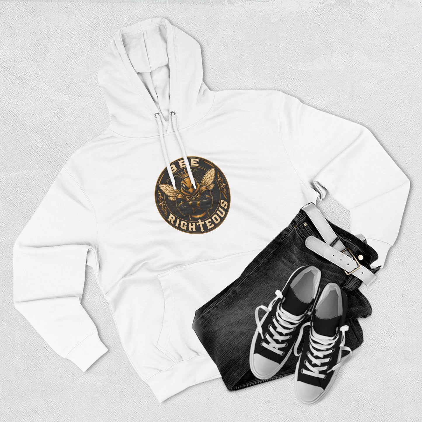 White hoodie with a logo, black jeans, and black sneakers on a light gray background