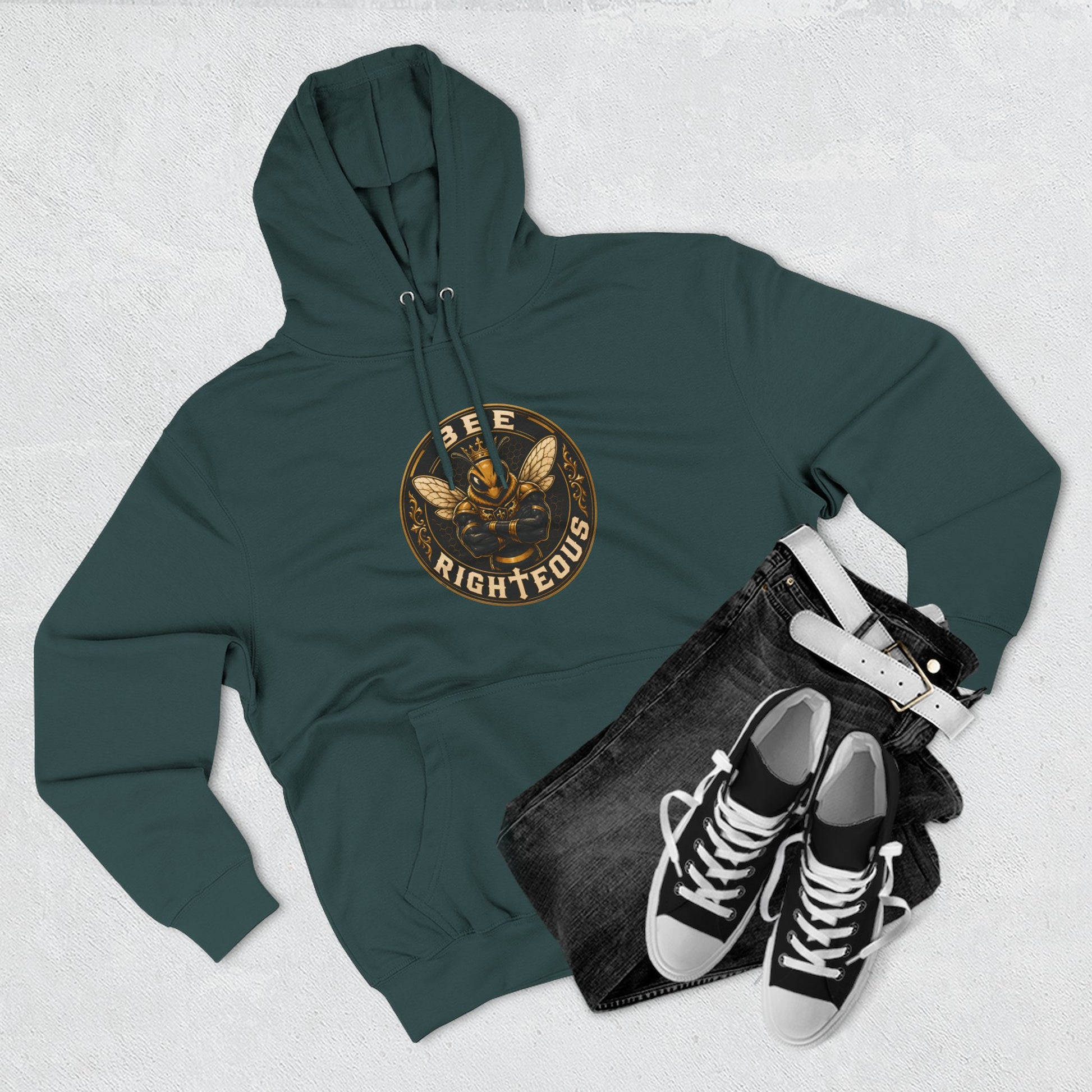 Green hoodie with graphic design, black jeans, and black sneakers on a light gray background
