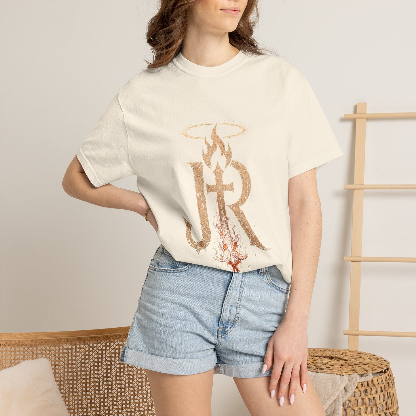 Person wearing a white t-shirt with a logo and denim shorts in a casual setting.