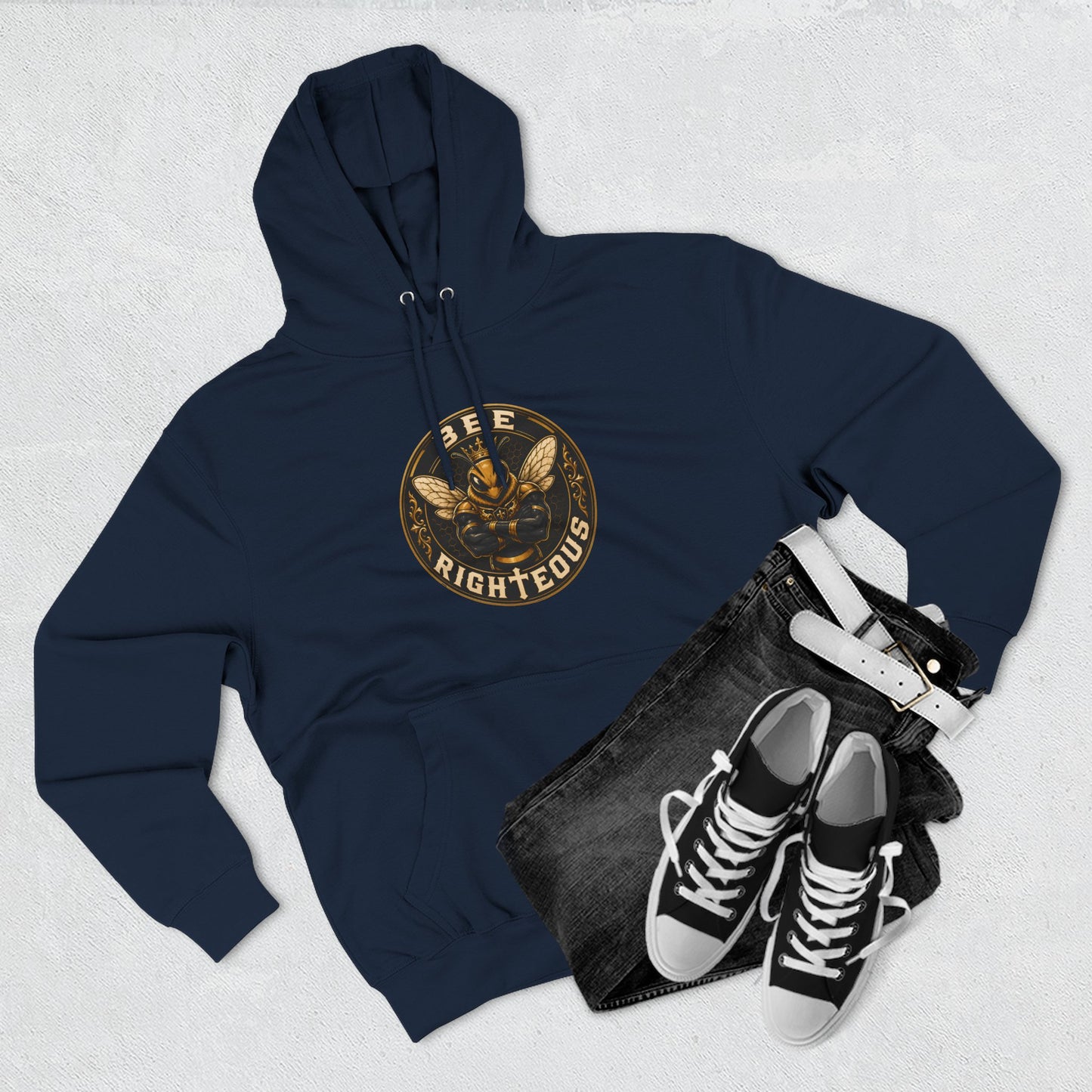 Navy hoodie with graphic design, black jeans, and black sneakers on a light gray background