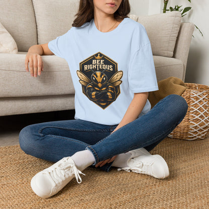 Person wearing a light blue t-shirt with a bee graphic and text, sitting on a couch.